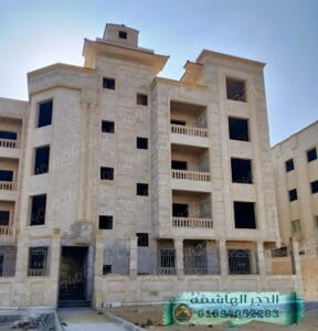 مبنى ذو واجهة متينة من حجر هاشمي رأس، يعكس الطابع المعماري الفاخر ومقاومة العوامل الجوية.